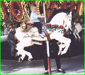 Merry-go-rounds with horses is a MUST for Daniel (Mom helps)
